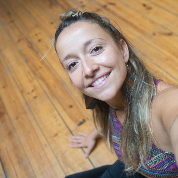 Smiling woman sitting in a lotus yoga pose feeling serene and happy.